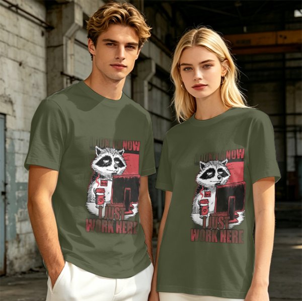 Olive graphic t-shirt with a tired raccoon office worker and 'I Just Work Here' text