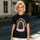 Olive graphic tee with black cat, rainbow, and 'Therapy Is Not Enough' text