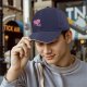 Black baseball cap with sad running pink heart graphic
