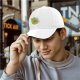 Black baseball cap with cute green cat holding orange yarn ball