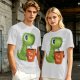 Olive green t-shirt with cute Tea Rex dinosaur holding a steaming tea mug