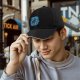 Black Baseball Cap With Playful Black Cat On Blue Abstract Background