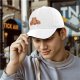 Black baseball cap with a winking bear graphic that says Here for the Snacks