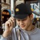 Black baseball cap with crying yellow duck and rainbow graphic