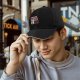Black baseball cap with raccoon graphic doing the bare minimum