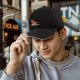 Black baseball cap with a relaxed cartoon pepper graphic and text