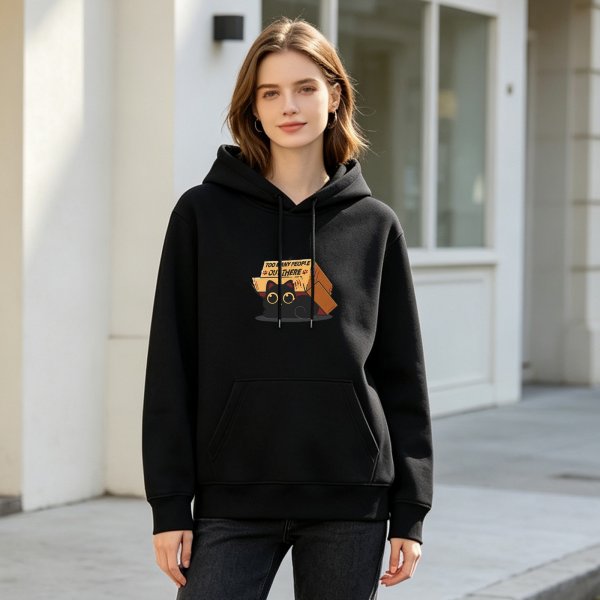 Black hoodie with a shy black cat hiding behind boxes that say too many people out there