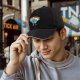 Black baseball cap with cartoon Earth graphic and 'I HATE PEOPLE' text